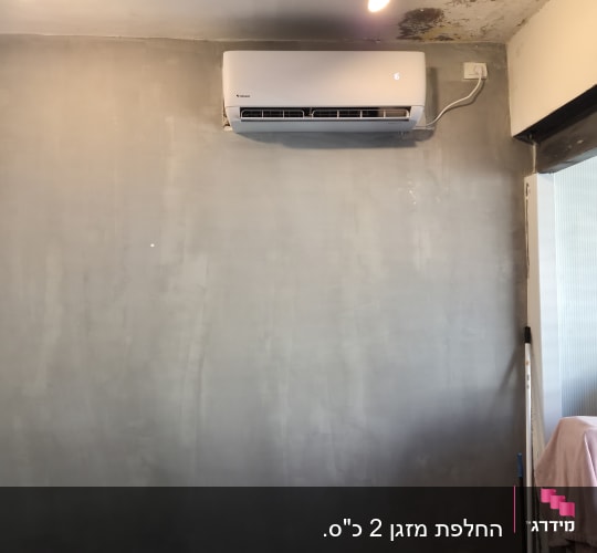 מזגן מותקן על קיר עם תאורה מעליו